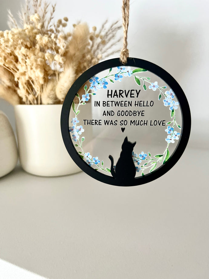black cat silhouette with blue floral forge me knot flowers. Cats name and inbetween hello and goodbye there was so much love is printed in black text with little heart